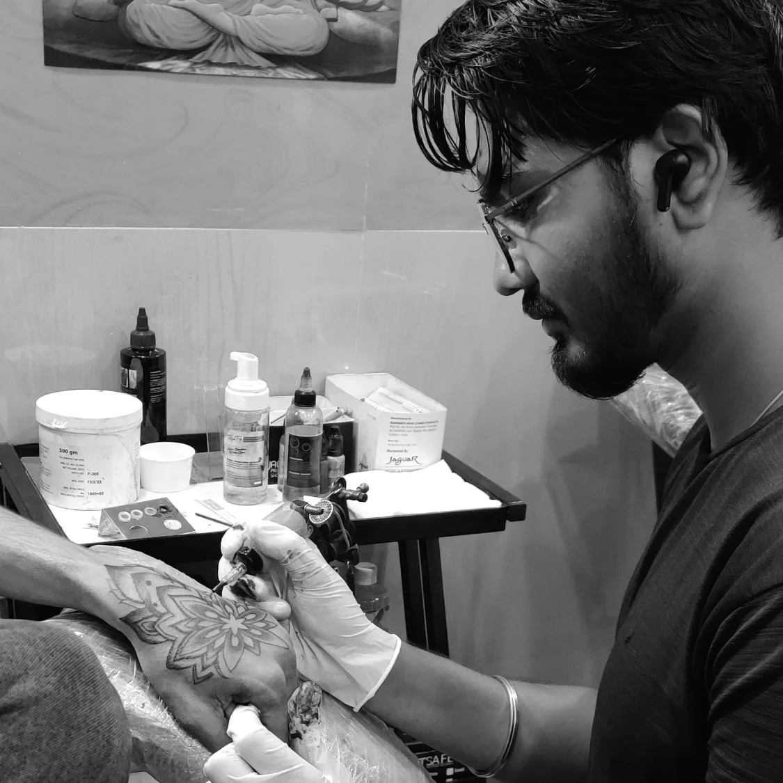 Tattoo artist Aakash Khavadiya working on a mandala hand tattoo at Dynamic Tattoo Studio